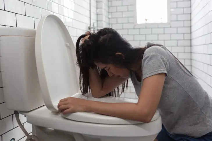 Een zakje O.R.S. poeder voor volwassenen naast een glas water, klaar om opgelost te worden voor gebruik